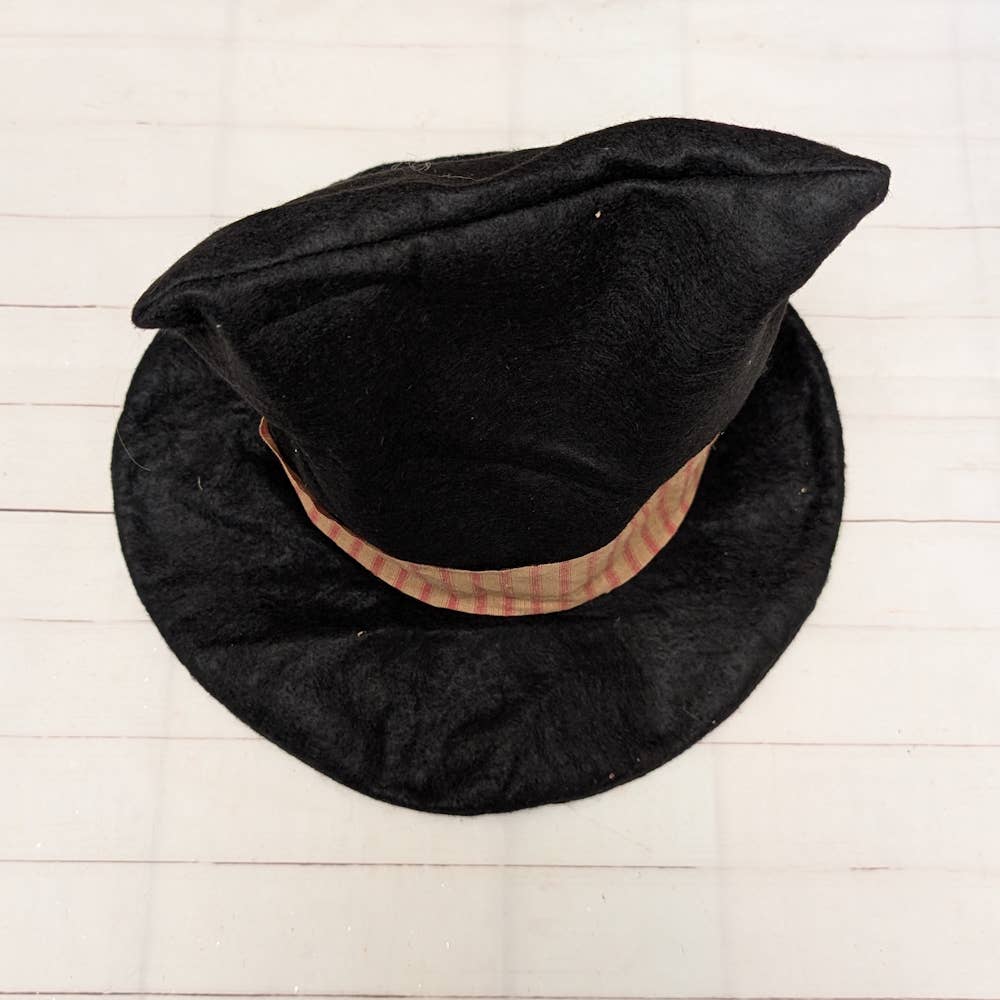 Black hat with a brown band on a light wooden surface